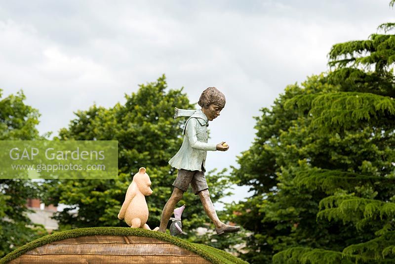 Detail from the flower show, Christopher Robin, Pooh Bear and Piglet stepping out on a curved artificial grass roof. RHS Hampton Court Flower Show in 2016