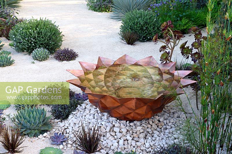 The Winton Beauty Of Mathematics Garden. Copper water basin in crushed stone and sandy bed. The RHS Chelsea Flower Show 2016, Designer: Nick Bailey, Sponsor: Winton