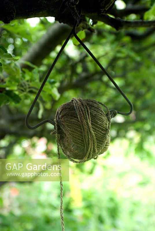 Ball of garden twine on hanger in tree