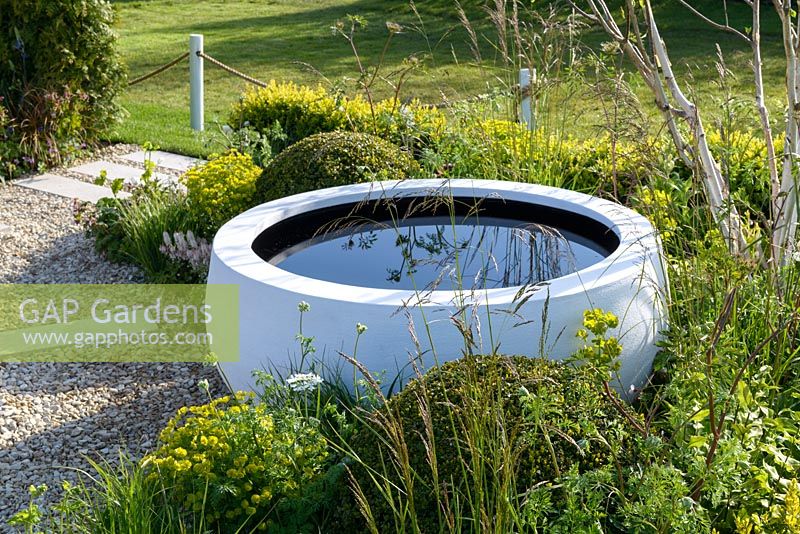 Water bowl by Urbis surrounded by Euphorbia and Buxux balls - Time is a Healer supporting Primrose Hospice, RHS Malvern Spring Festival 2016. Design: Wilson Associates Garden Design. Bronze Medal and People's Choice Award