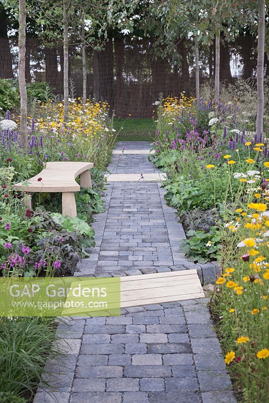 A granite setts and wooden path with rows of crab apple trees, wildflowers and perennials. A stitch in time saves nine garden. RHS Tatton Flower Show 2011, Cheshire