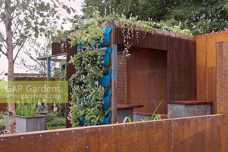 A contemporary corten steel summerhouse with living roof and hanging plant pouches. Rider on the Storm, RHS Tatton Flower Show 2011, Cheshire

