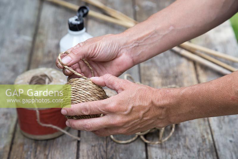 Using PVA glue to secure string around an old tennis ball to create cane toppers