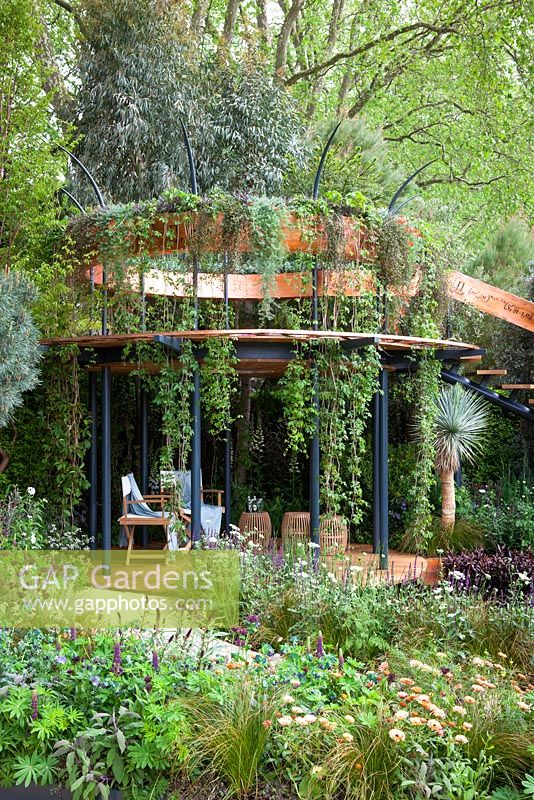 Belvedere in the Winton Beauty of Mathematics Garden, Chelsea Flower Show 2016. Mathematical symbols cut into band of copper used as bannister for staircase. Pinus sylvestris 'Glauca' - blue Scot's pine, Yucca rostrata - Beaked Yucca