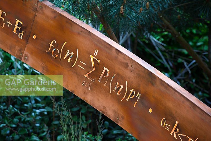 Detail of illuminated mathematical symbols cut into band of copper to form bannister for staircase leading up the belvedere in the Winton Beauty of Mathematics,Chelsea Flower Show 2016.