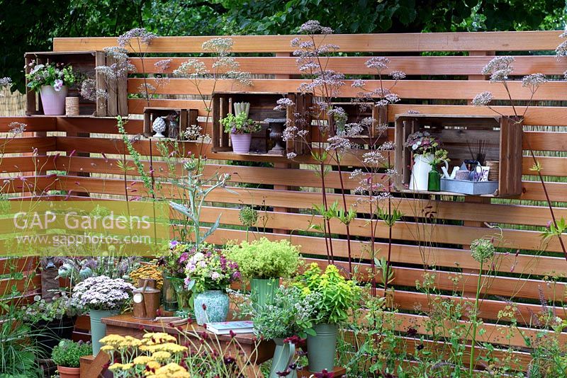 Katie's Garden. Cut flowers in wooden crates hung on timber fencing. Designers: Carolyn Dunster and Noemi Mercurelli. Sponsors: Katie's Lymphoedema Fund. RHS Hampton Court Palace Flower Show 2016