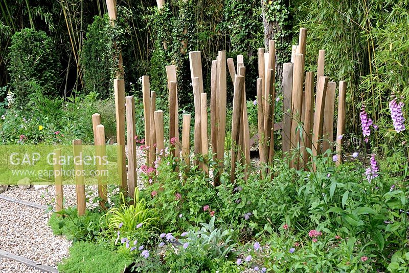 Wooden fence in a cottage garden'Nous irons tous au jardin' designed by Laurent Dabomprez and Gaelle Van Damme at the Festival International des Jardins 2016, Chaumont-sur-Loire, France