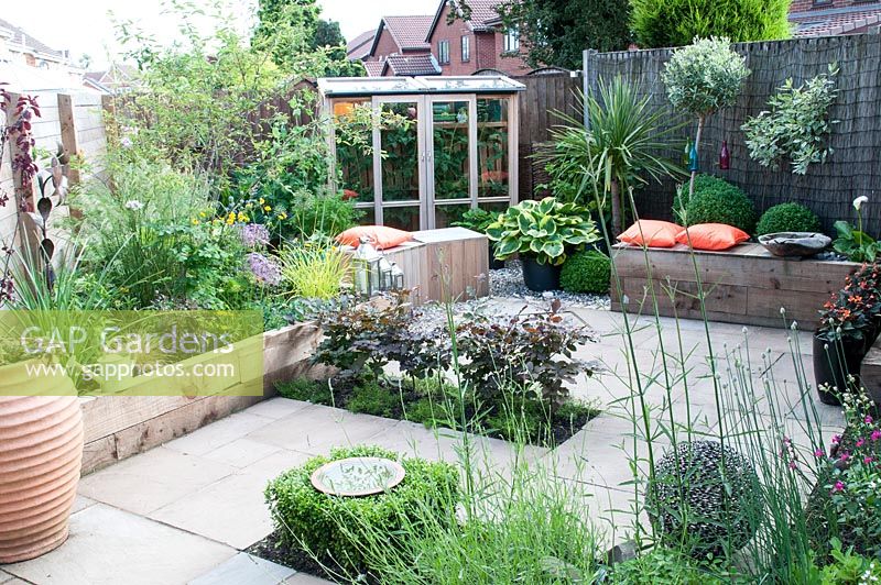 Suburban courtyard garden with wooden block seats and bench