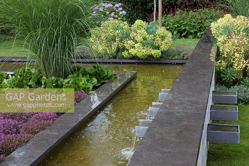 Detail pond with wall fountain and border with Thymus.