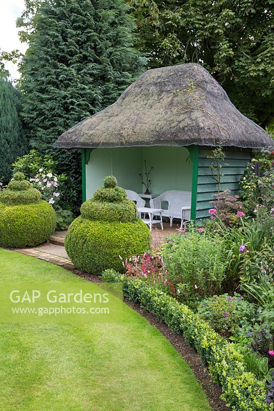 Summer house with box topiary at entrance