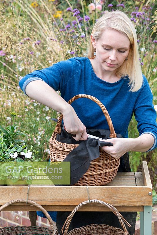 Step-by-Step planting autumn baskets: the permeable fabric is trimmed level with the top edge of the basket.