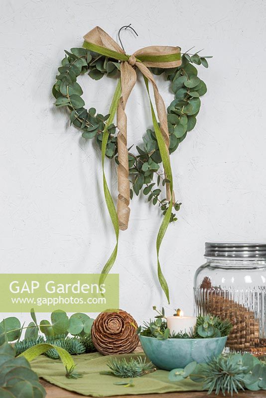 A Eucalyptus wreath with decorative ribbon hanging on a wall