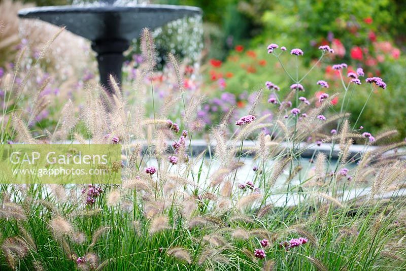 Pennisetum alopecuroides 'Cassian' and Verbena bonariensis float around the fountain in the Italian garden whilst roses bring bright splashes of colours in les Jardins de la Poterie Hillen.