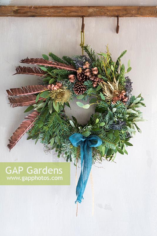 A festive Christmas wreath made with Eucalyptus, Pine cones, Pine foliage and Pheasant feathers