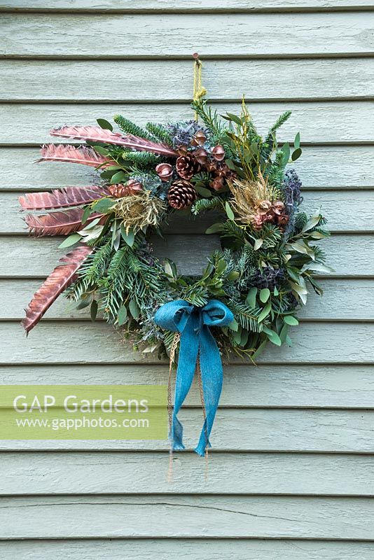 A festive Christmas wreath made with Eucalyptus, Pine cones, Pine foliage and Pheasant feathers