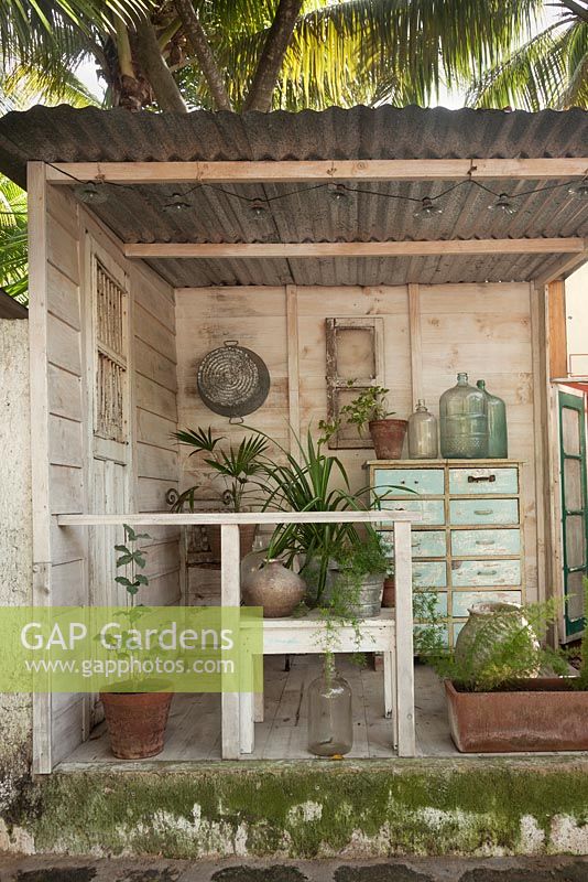 Open-sided wooden shed with corrugated metal roof and decorative features