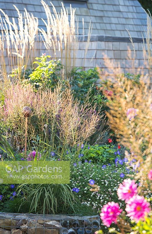 Late summer border in pub garden with raised stone bed. Jo Thompson garden Design, Ticehurst, East Sussex