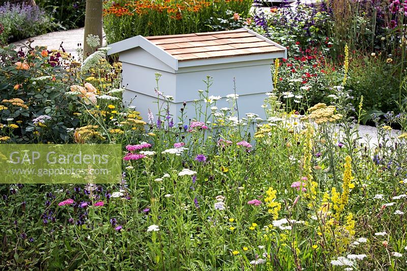 Hampton Court Flower Show, 2017. 'It's all about Community' garden, des. Andrew Fisher Tomlin and Dan Bowyer. Beehive amongst wildflowers