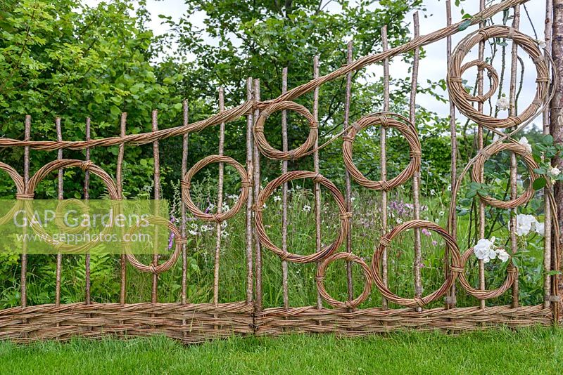 Woven wicker fence with flowering Trachelospermum jasminoides - star jasmine. Belmond Enchanted Gardens - RHS Chatsworth Flower Show 2017 - Designer: Butter Wakefield - Gold - People's Choice