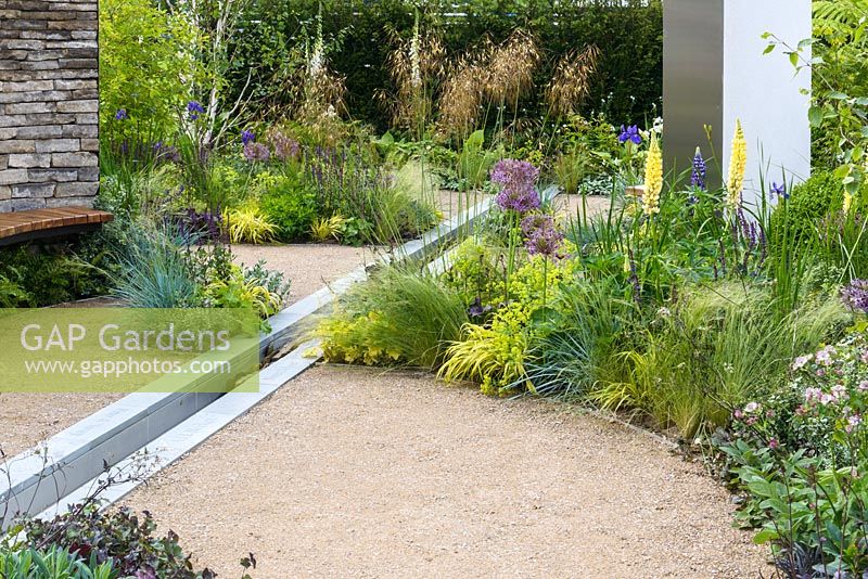 Dry stone walling, wooden bench seat, water feature rill channel and beds of herbaceous perennials, shrubs and trees - Cruse Bereavement Care: 'A Time for Everything' - RHS Chatsworth Flower Show 2017 - Designer: Neil Sutcliffe - Sponsor: London Stone