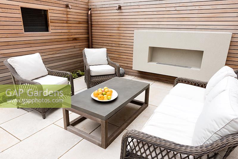 Seating area on patio surrounded by cedar panelling 