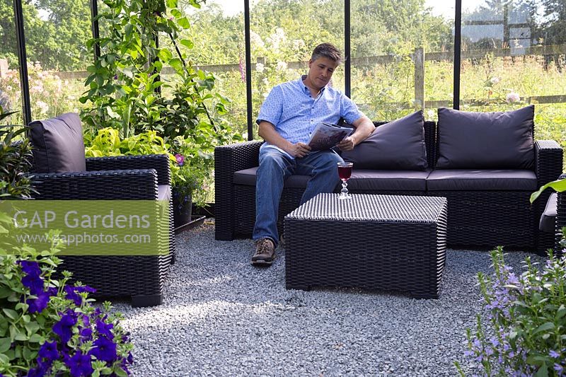 Man relaxing in modern greenhouse