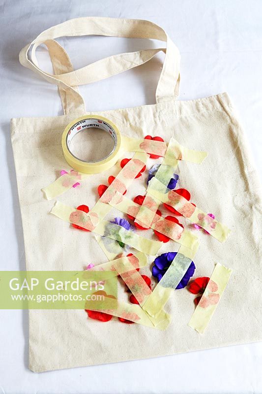 Printing onto fabric bag with fresh flowers. Remove the stems from the flowerheads and lay the flowers face down on to your bag in the pattern you want and secure with pieces of masking tape