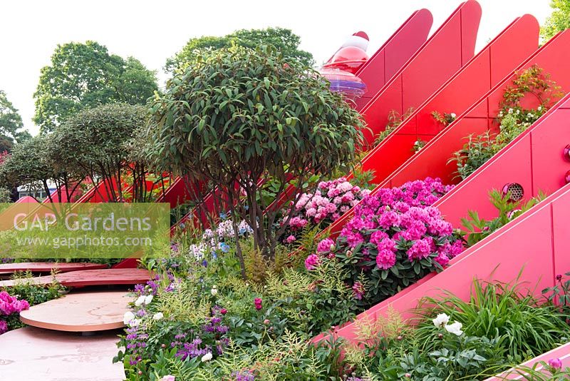 Coloured fins with insect houses, interplanted with Viburnum davidii, Rhododendron and herbaceous perennials - The Chengdu Silk Road Garden - RHS Chelsea flower show 2017 - Designer: Laurie Chetwood and Patrick Collins