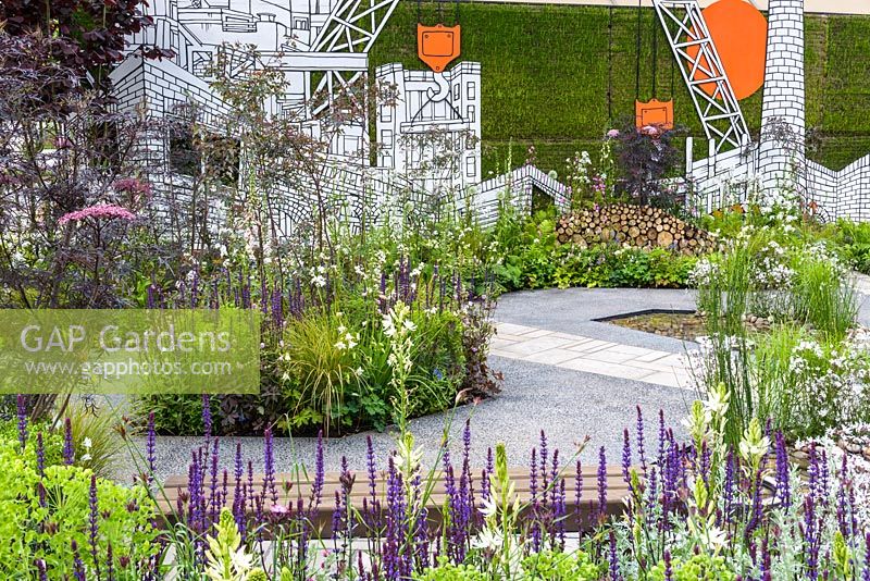 Perennial planting with Salvia against a wall of street art, created by Sheffield urban artist Jo Peel in Greening Grey Britain Garden - RHS Chelsea Flower Show 2017 - 