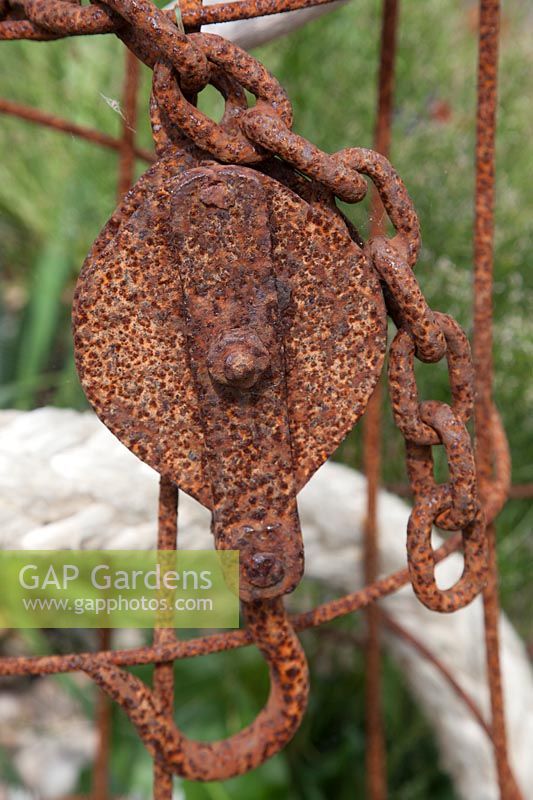 Rusted metal chain and pulley sculpture