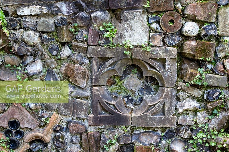 Part of the 'Medieval' wall incorporating ornamental bricks, flints, bottle ends and broken pieces of brick. The trailing plant is Cymbalaria muralis - Kenilworth Ivy.