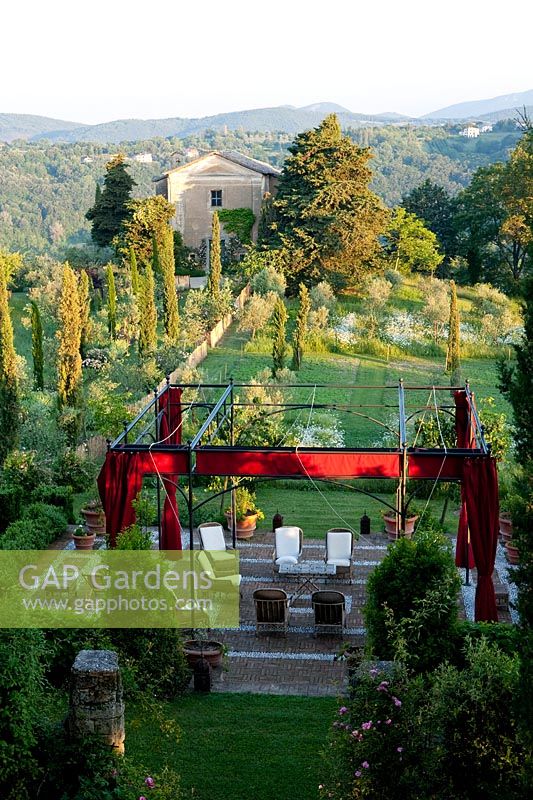 View down to seating area in the mediterranean garden at Palazzo Parisi. Oliveto, Rieti, Italy.