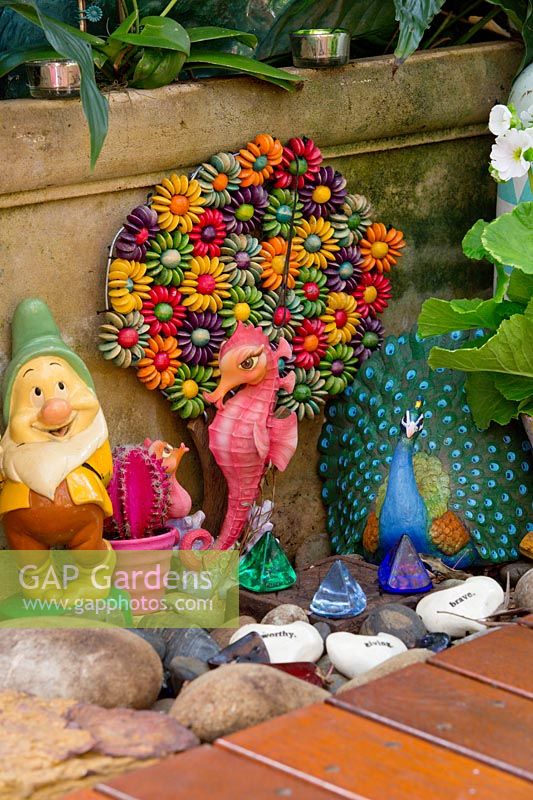 Clorful garden ornaments including garden gnome and flowers made from beads, June.