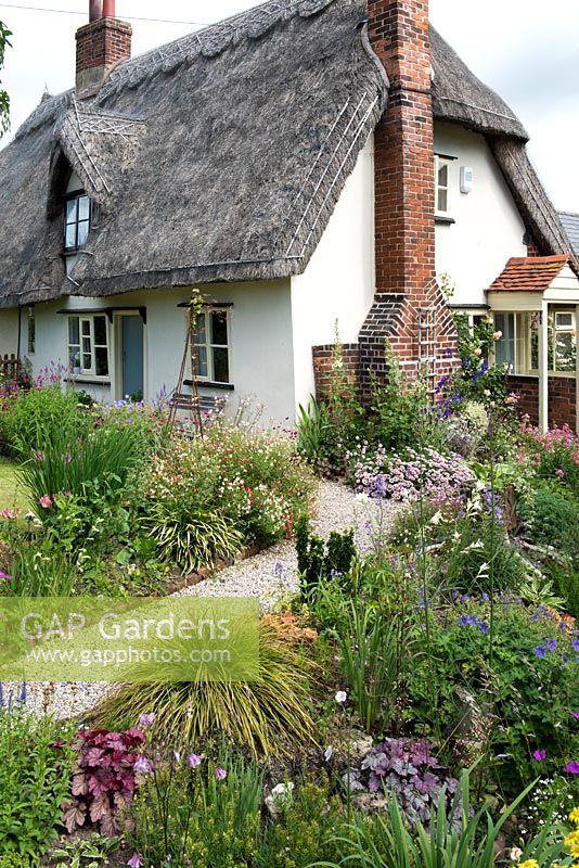 Caynton Cottage, a seventeenth century thatched cottage, is reached via gravel paths edged in perennials.