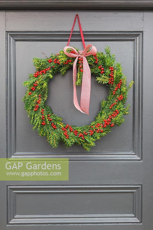 Festive Christmas wreath hanging on a wooden door