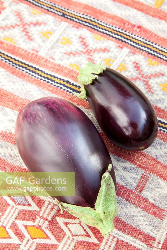 Fresh Aubergines on a kilim covered table