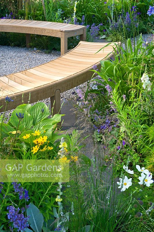 Contemporary garden with curved wooden benches. Designers Catherine Chenery Barbara Harfleet