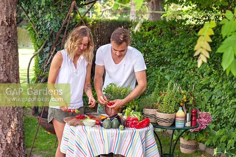Young couple barbecueing in the garden
