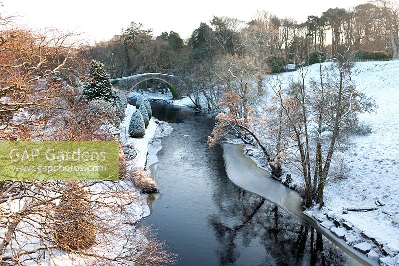 Golden winter sunlight and snow at the Auld Brig O'Doon, Alloway, Ayrshire, Scotland