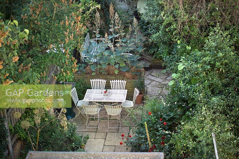 Urban back garden with patio furniture, paving, patio heater and paving