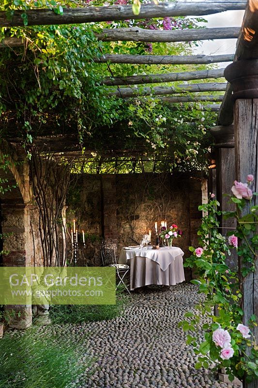 Table and chairs set for a meal in a quiet alcove at Borgo Santo Pietro, Tuscany, Italy