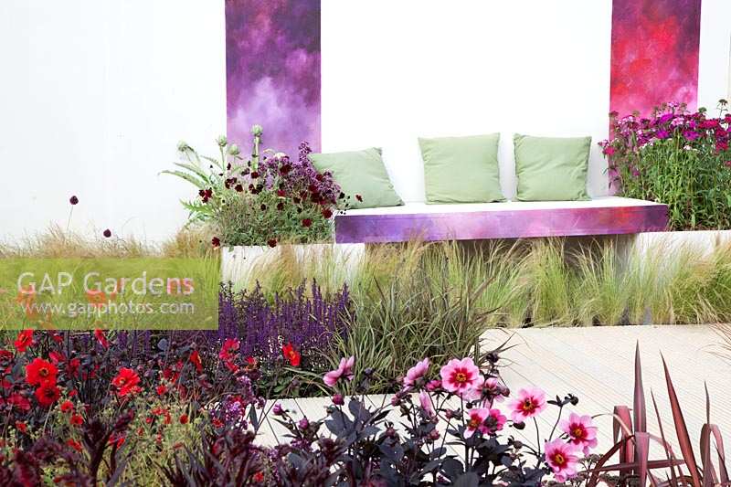 Contemporary patio with Dahlia, Dianthus, Anemone and ornamental grasses, sitting area in the background