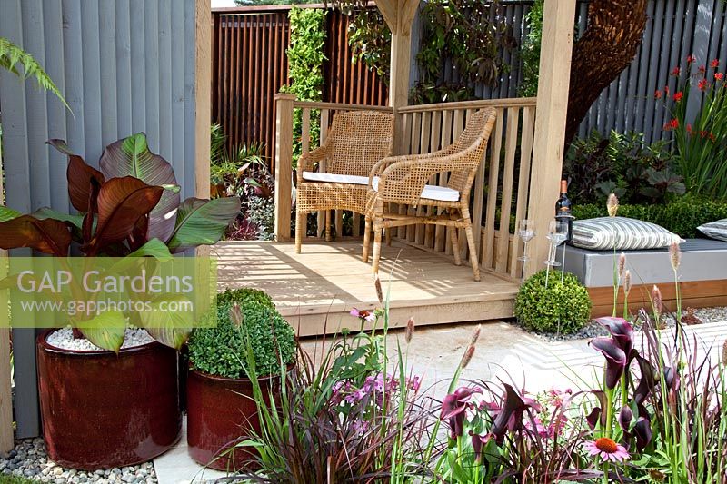 Wooden patio with container plants, garden furniture, garden bench