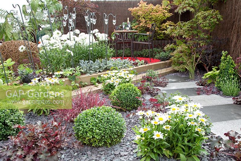 Garden patio with perennials, ornamental shrubs and grasses