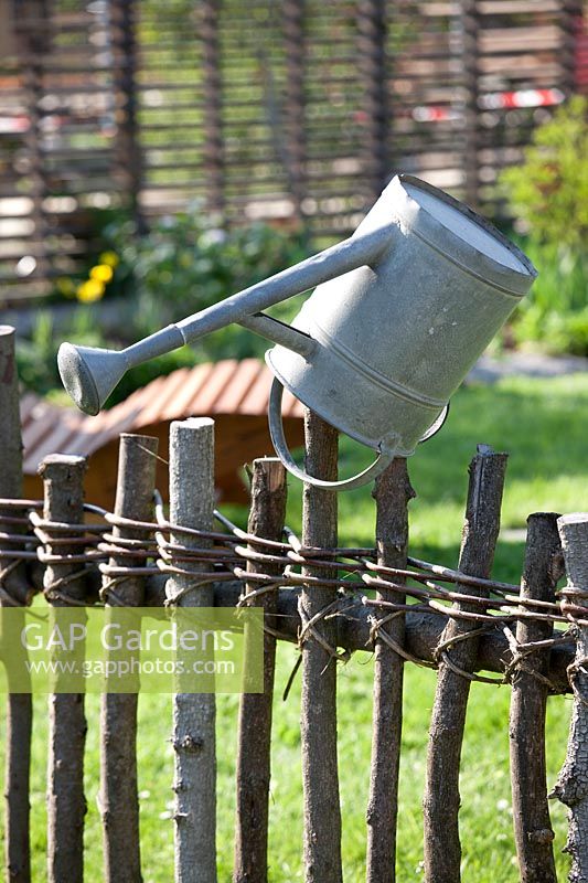Watering can on the wooden fence