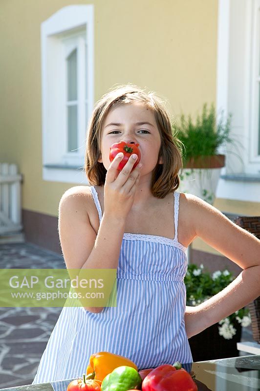 Girl eating a tomato