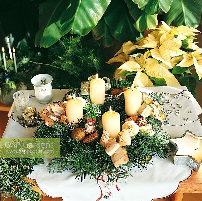 Adventskranz mit cremefarbenen Dekor und Kerzenlicht