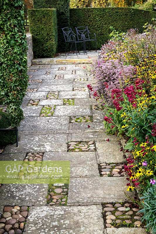 Bourton House Garden, autumn, deep informal autumnal  borders with paved path