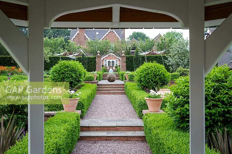 Mitton Manor, Staffordshire. Formal garden parterre with Neil Wilkin glass 'Suncatcher' sculptures