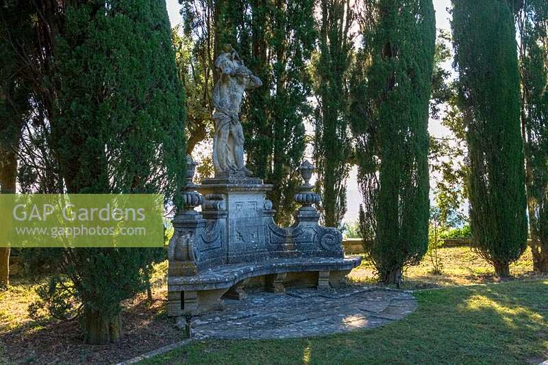 Villa La Foce, Tuscany, Italy. Large garden with topiary clipped Box hedging and views across the Tuscan countryside, statue in lower terrace garden